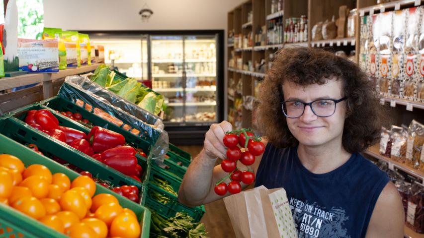 Bewohner kauft frisches Gemüse im nahegelegenen Hofladen ein